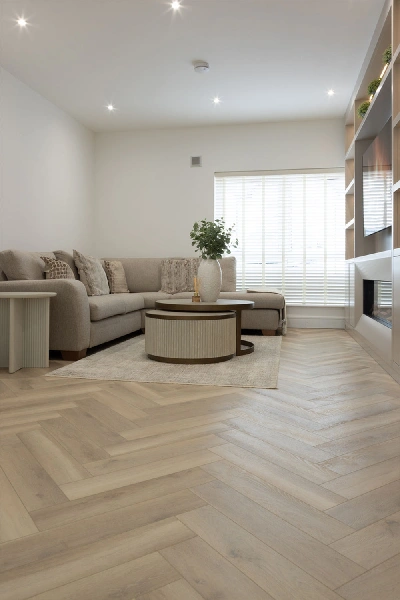 Light oak herringbone SPC flooring in a living room.