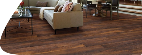 Rich walnut wood flooring in modern open living space.
