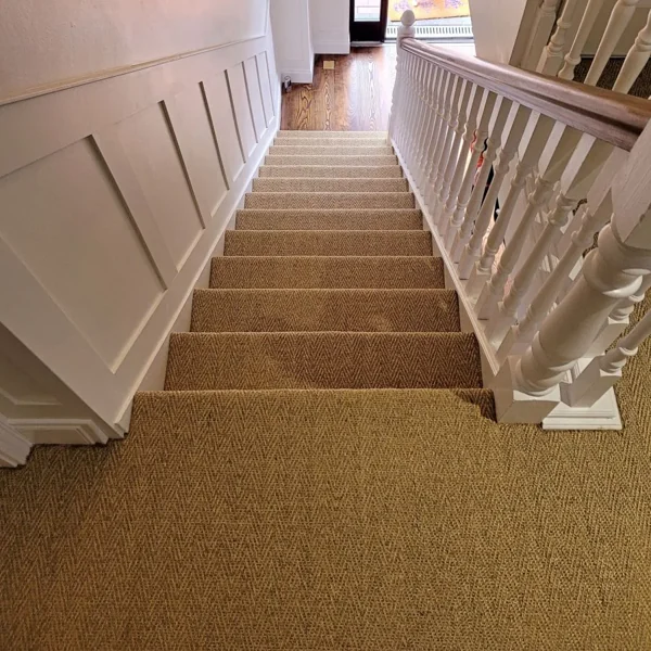 Chevron pattern sisal carpet installed on a home staircase