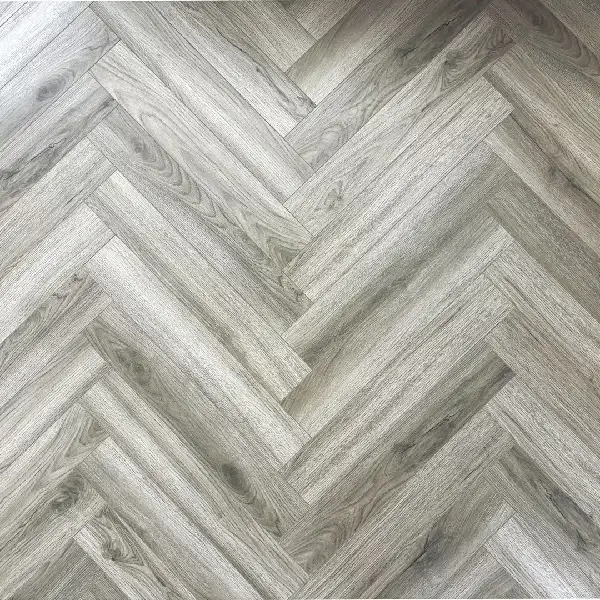 textured medium gray laminate flooring in a herringbone pattern.