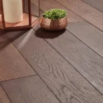 A close-up of dark brown wood planks featuring a decorative candle