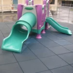 A teal and purple slide on blue rubber safety flooring