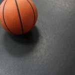 Basketball resting on a durable black rubber mat