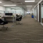 Brown carpet tiles with a wavy, rippling pattern in an office corridor.