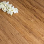 Close-up of carbonized dark bamboo flooring with white orchids
