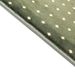 Close-up of green carpet texture with white diamond pattern.
