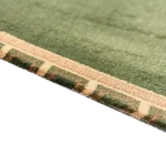 Close-up of green prayer rug texture and hem.