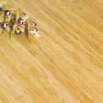 Close-up of light bamboo flooring texture with orchid flowers.
