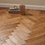 Close-up of textured oak herringbone flooring.