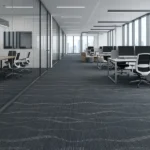 Dark grey carpet tiles featuring a subtle wavy pattern in a modern office