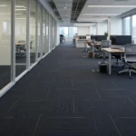 Dark grey patterned carpet tiles in an office corridor.