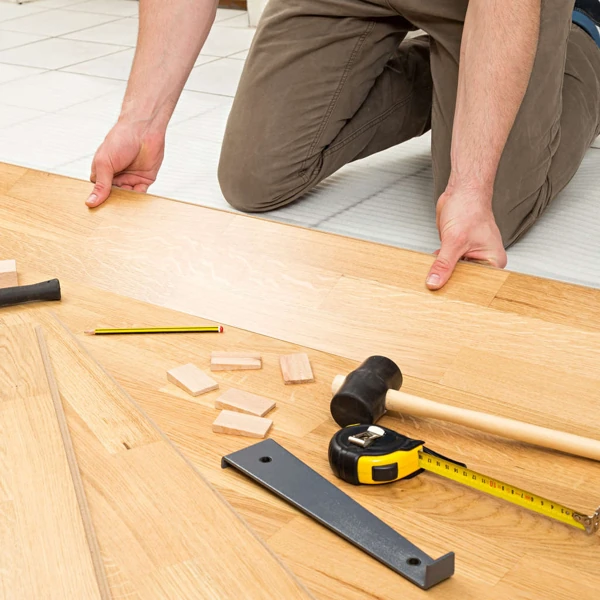 Professional installing light wood flooring planks