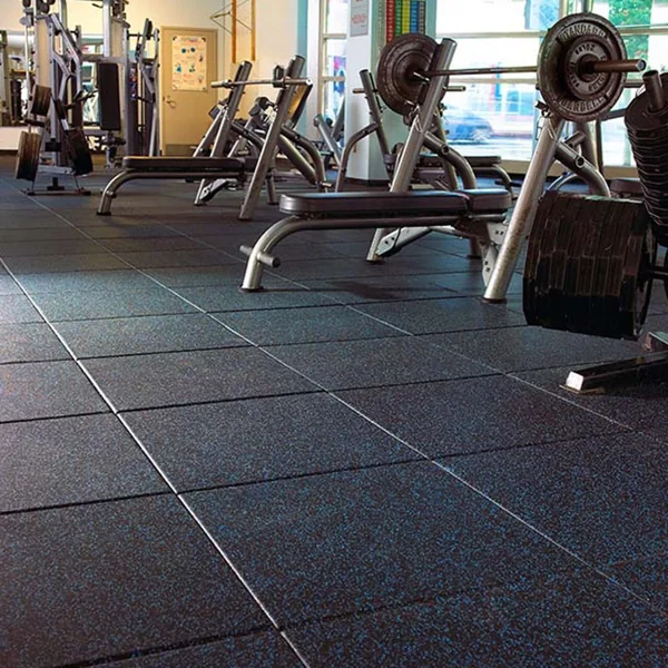 Interlocking speckled blue and black rubber tiles in a commercial gym