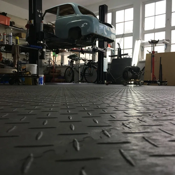 Black diamond-plate rubber flooring in an automotive repair garage