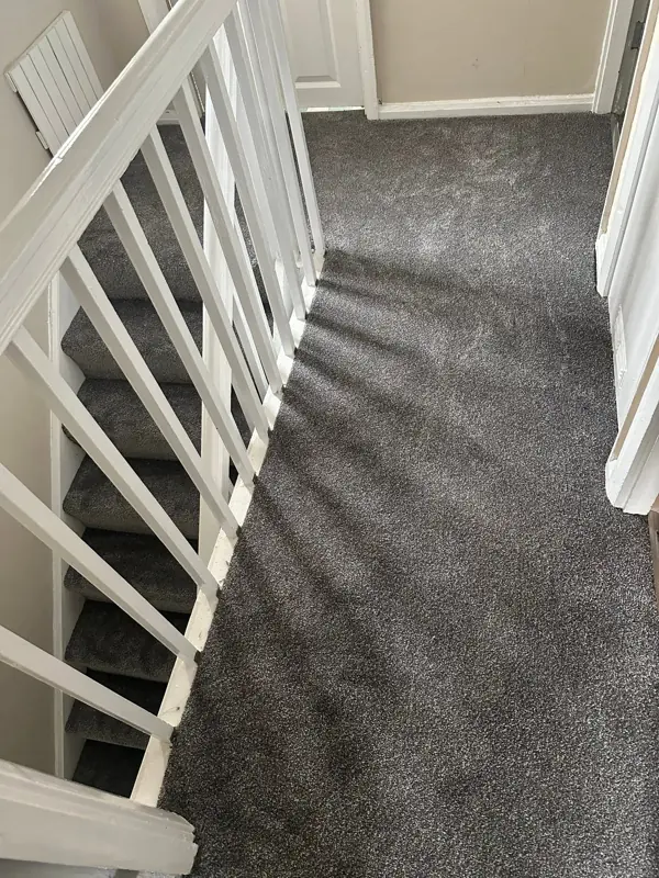 Grey wall-to-wall carpet on landing and stairs