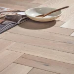 Light herringbone wood floor with a decorative bowl.
