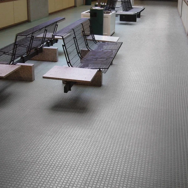 Grey coin-pattern rubber flooring in a public waiting lobby area