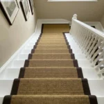 Looking down white stairs with a gold stair runner