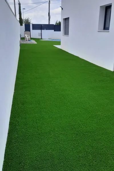 Lush green artificial grass carpet installed in a lawn