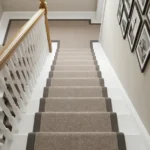 Neutral stair runner curving upward past gallery wall