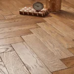 Oak wood flooring in a classic herringbone layout.