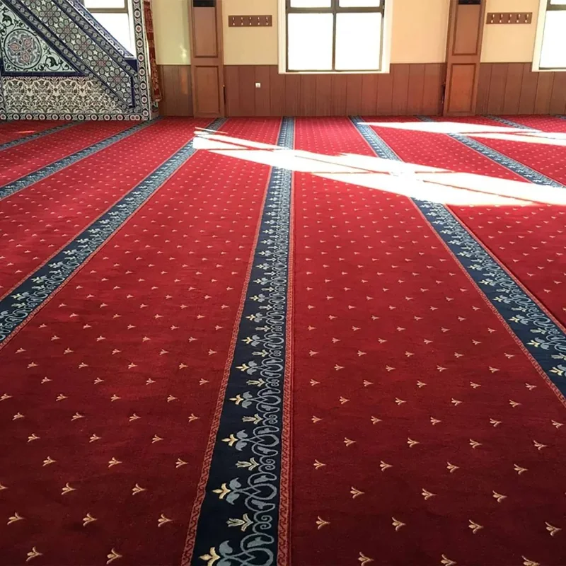 Red patterned mosque carpet in a bright hall