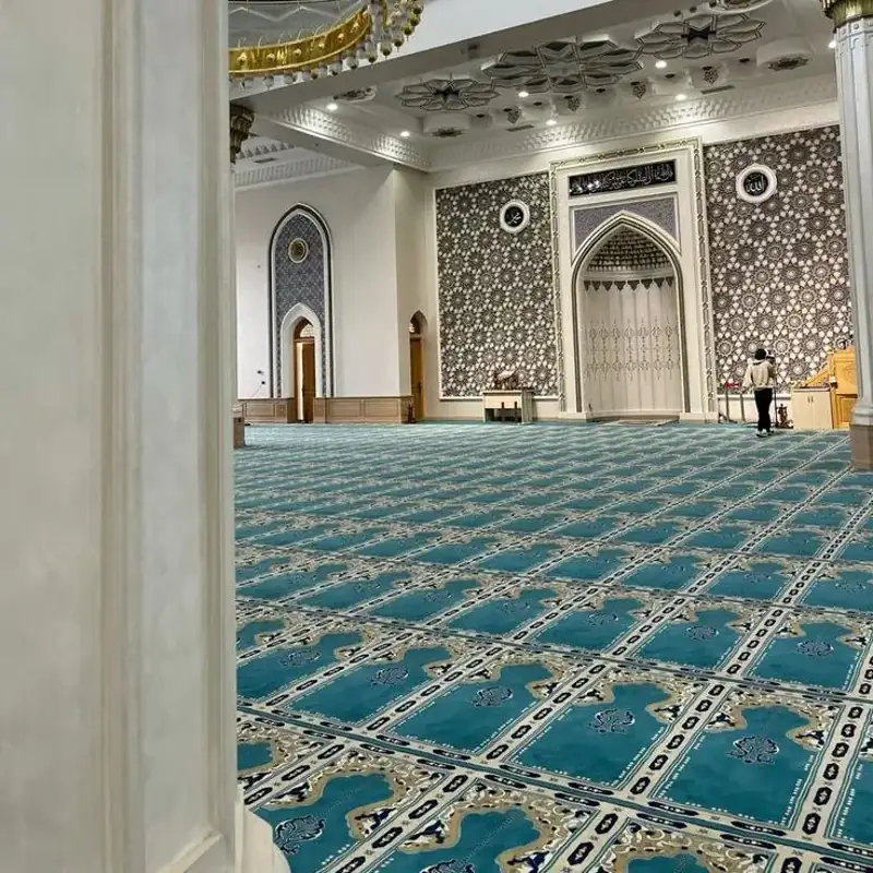 Red patterned mosque carpet under arched ceilings