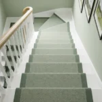 Sage green stair runner on winding white steps