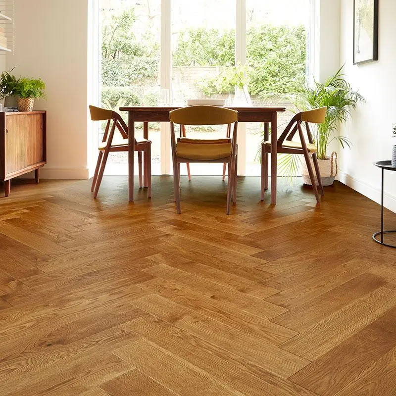Solid wood flooring in a golden-brown herringbone pattern