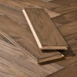 Two planks of dark herringbone wood flooring.