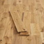 Two planks of natural oak flooring displayed on a wooden floor.