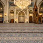 grey floral mosque carpet with stitched edge.