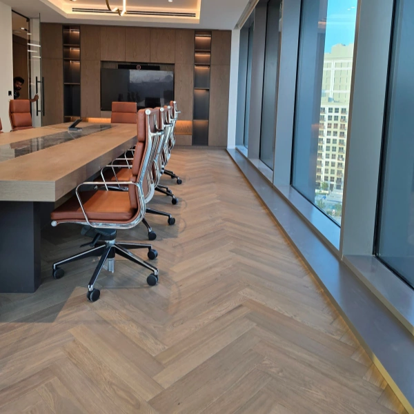 herringbone patterned wood flooring in a large, modern conference room.