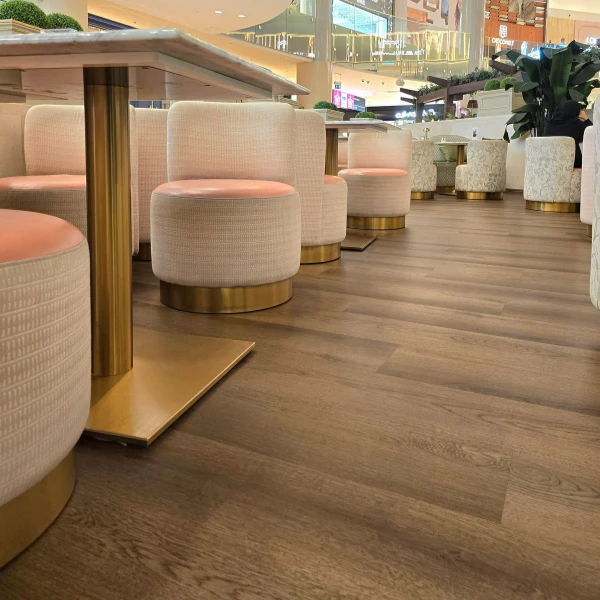 wide-plank wood flooring in a commercial cafe setting with warm lighting.