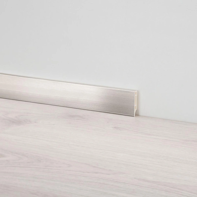 Brushed silver PVC skirting profile along a wall