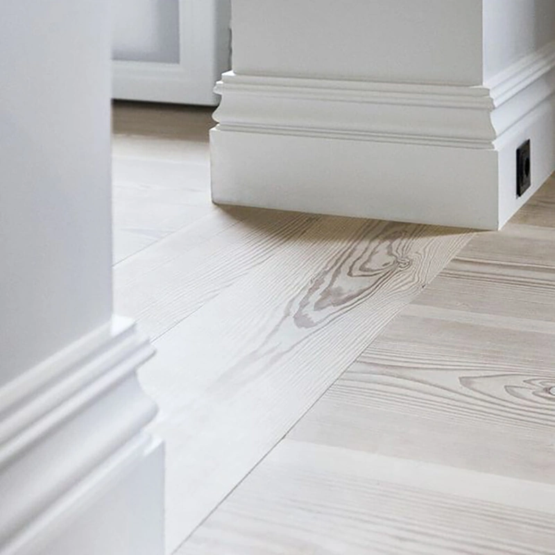 Detailed white MDF skirting board on oak flooring