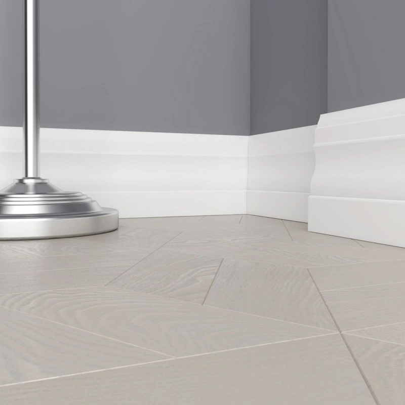 High white MDF skirting profile on chevron flooring
