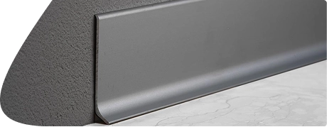 Matt gray aluminum baseboard trim on marble flooring