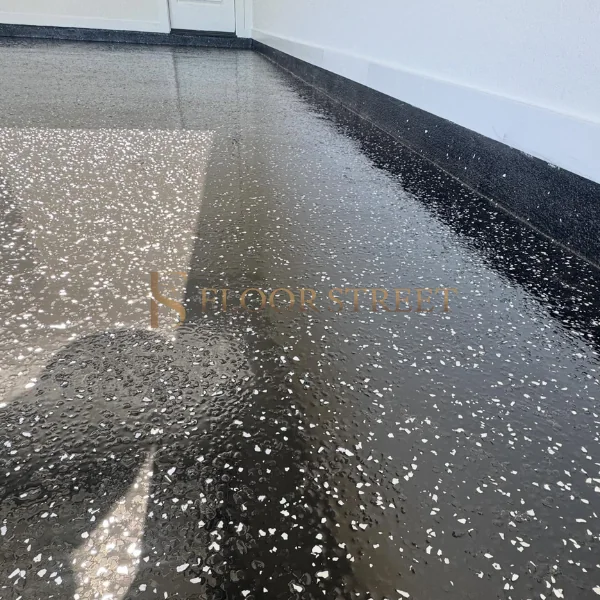 Modern black garage floor with white decorative chips.