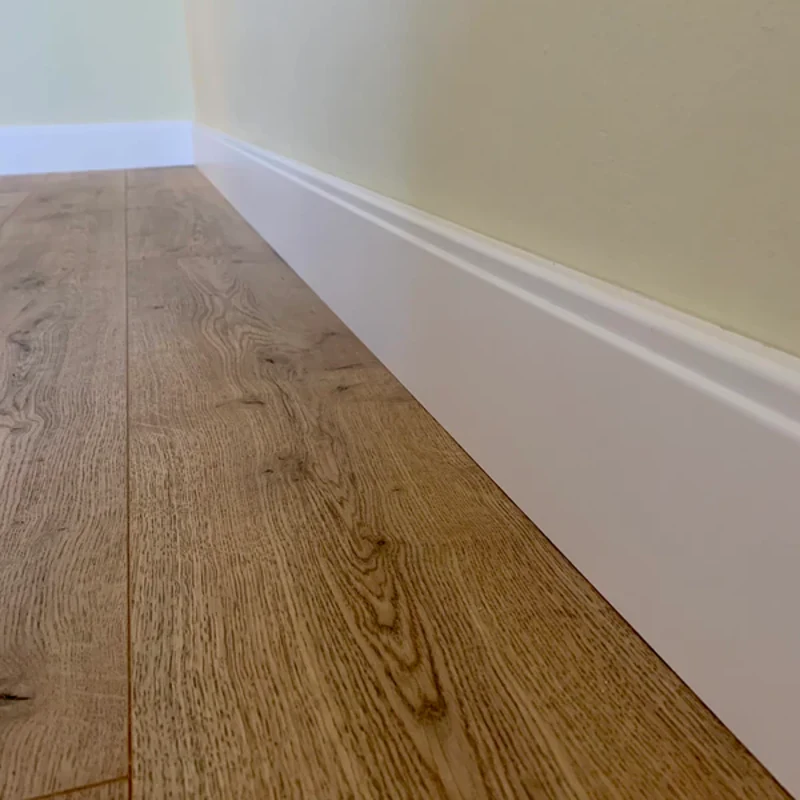 Sleek modern white MDF skirting board on oak floor