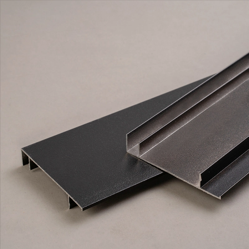 Slim silver metal baseboard on light wood flooring