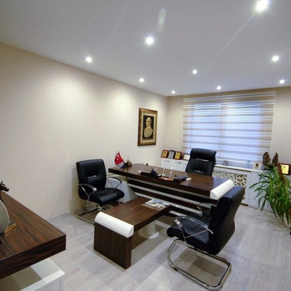 Thin white skirting board matching the office walls.