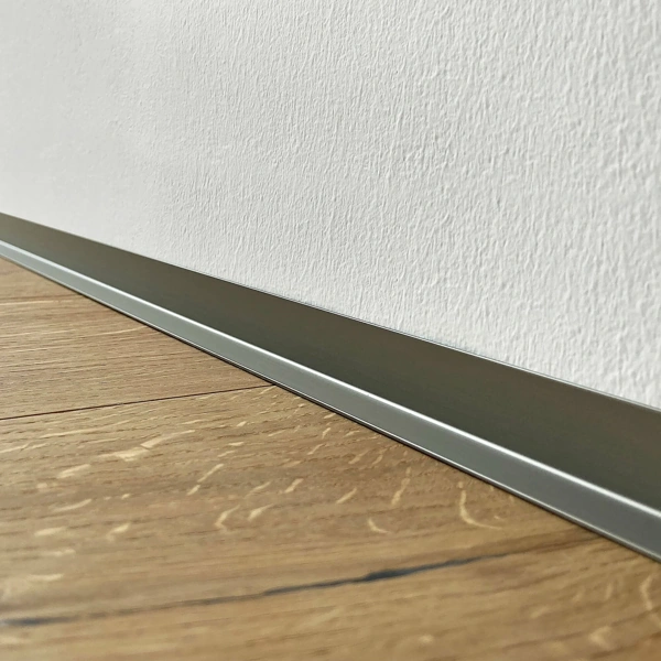 Two dark aluminum baseboard profile extrusions