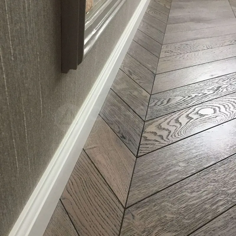 White MDF skirting board on chevron parquet floor