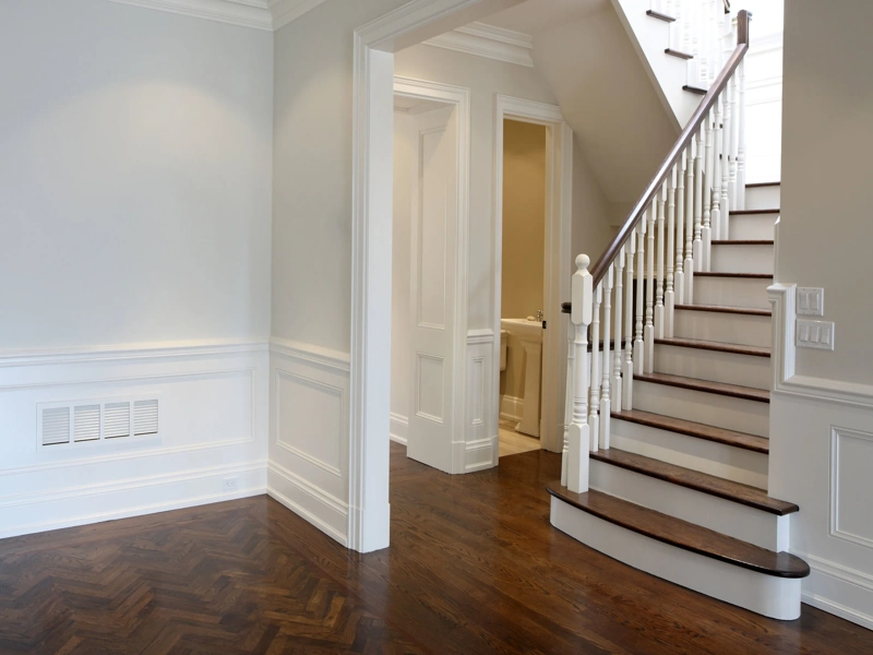 White wall paneling and skirting board by a staircase