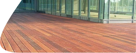 Wooden interlocking deck tiles on a balcony with grass