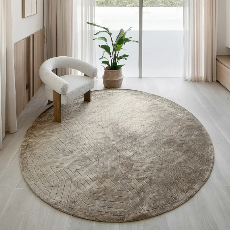 taupe-colored round carpet with a geometric, zigzag pattern
